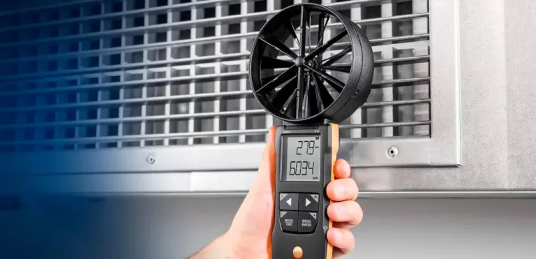 Especialista realizando medição de vazão e velocidade do fluxo de ar com anemômetro digital de hélice na grelha de climatização